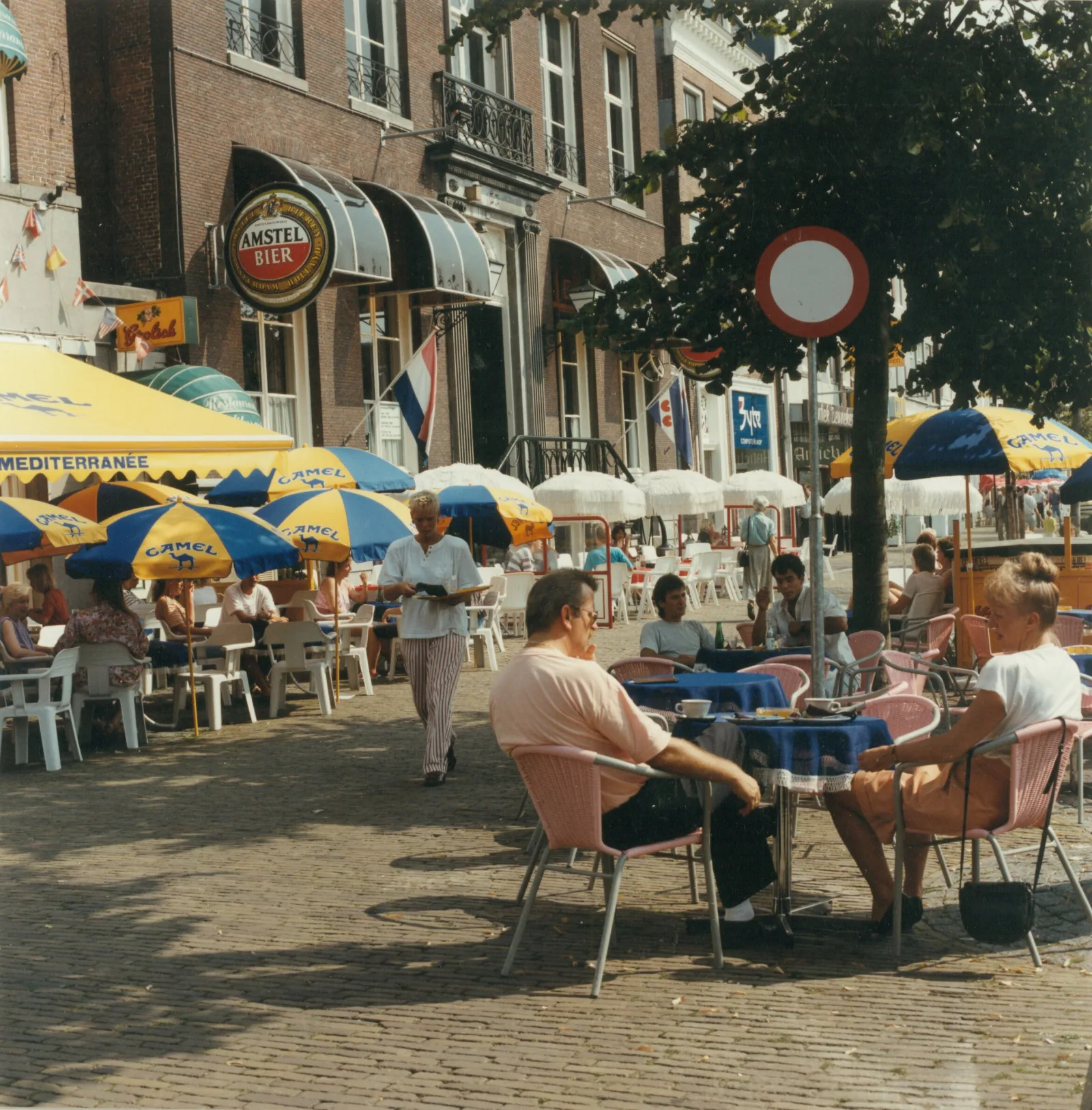 Vol terras met parasols op de Nieuwestad in Leeuwarden, gasten genieten van eten en drinken in het Friese stadshart