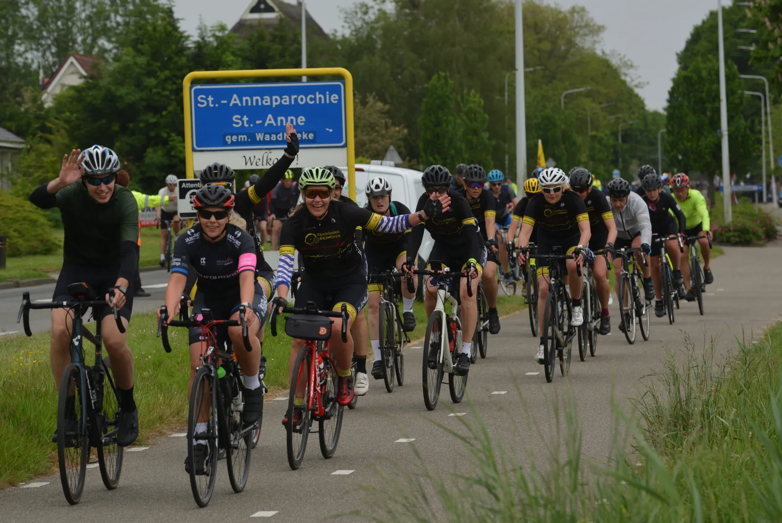 Peloton fietsers tijdens de Fietselfstedentocht 2024 passeert het plaatsnaambord St.-Annaparochie in Friesland