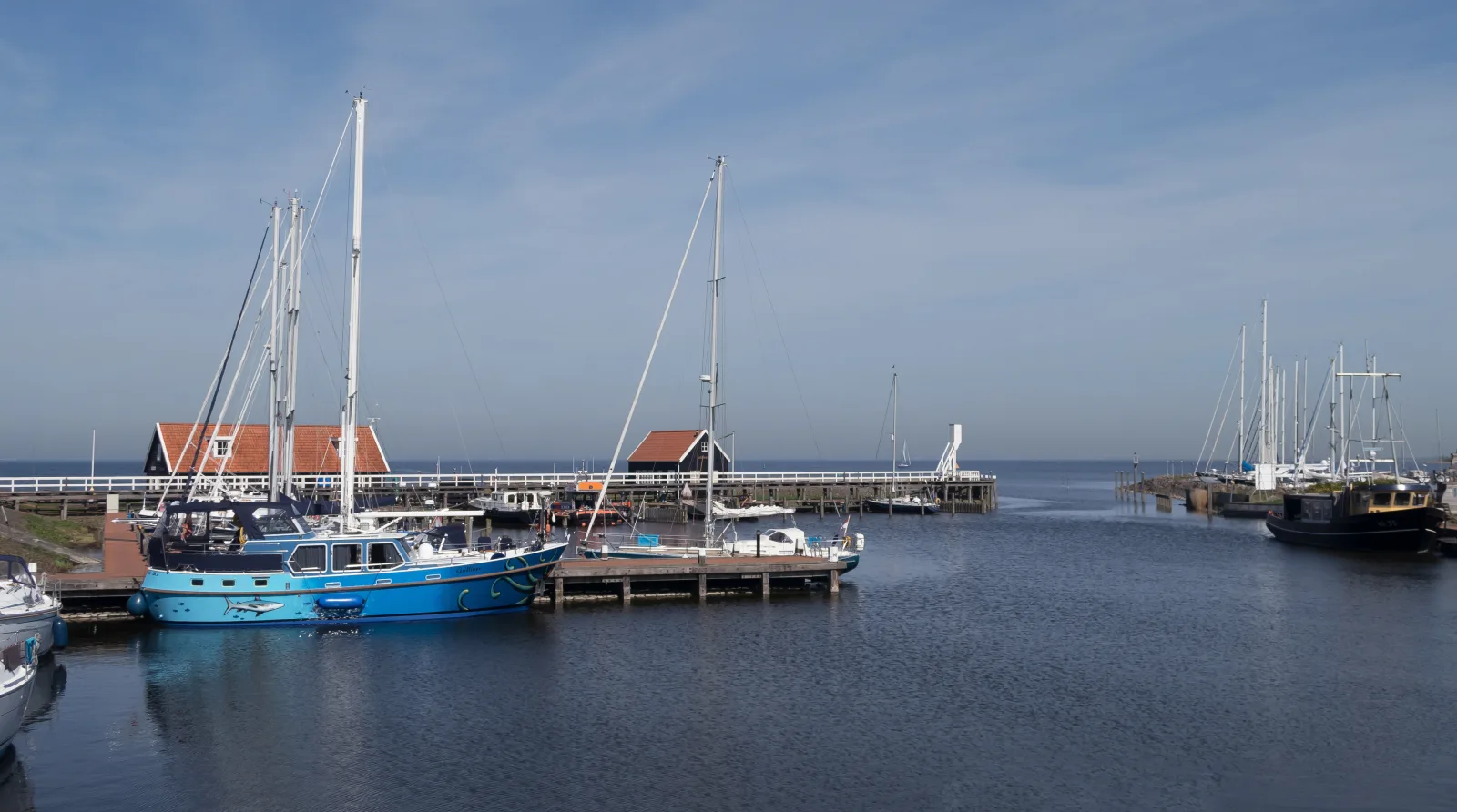 De jachthaven van Hindeloopen met zeilboten, houten steigers en de karakteristieke huisjes van het oude vissersstadje