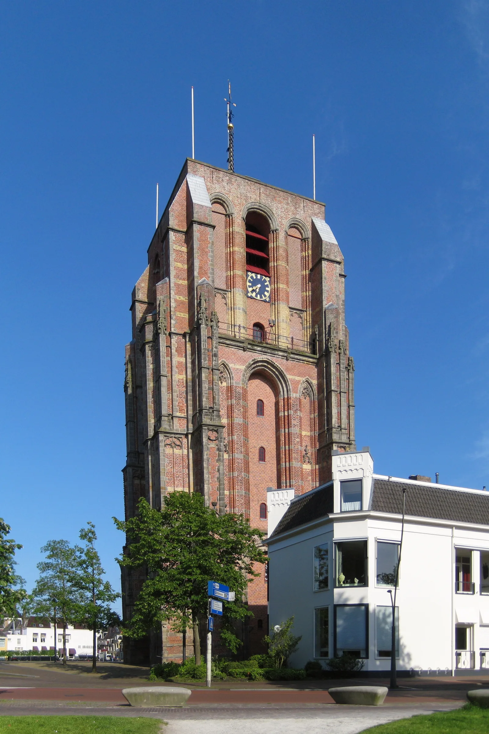 De scheve Oldehove-toren van Leeuwarden, een onvoltooide kerktoren uit 1529, tegen een strakblauwe zomerhemel
